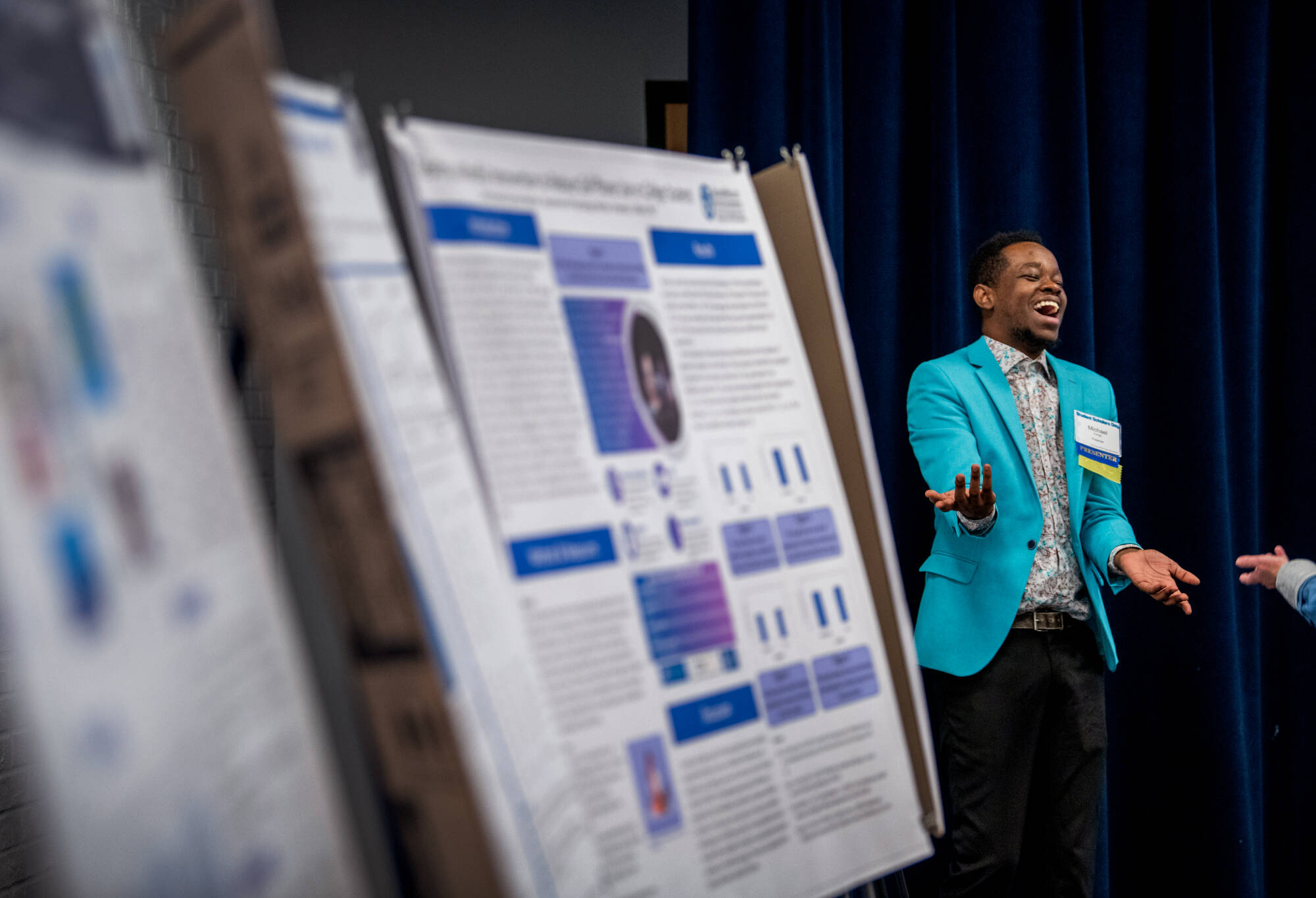 Student laughs while presenting a project.